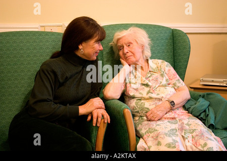 mittlere gealterte Frau/Tochter/Pflegedienst Besuch sehr alte Dame / ihre Mutter im Pflegeheim Stockfoto