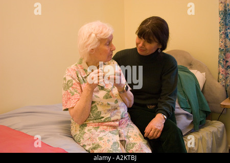 mittlere gealterte Frau/Tochter/Pflegedienst besuchen alte Dame / ihre Mutter im Pflegeheim Stockfoto