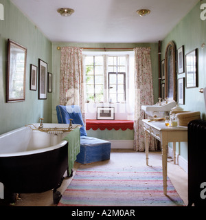 Badezimmer mit freistehender Badewanne, Schminktisch und alten altmodischen Becken. Stockfoto