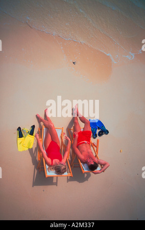 Luftaufnahme eines Paares, das Tragen von Badekleidung sitzen auf Stühlen am Strand am Rande des Wassers mit Schnorchel Masken und Flossen Stockfoto