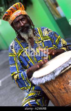 Bunte Rasta jamaikanischen Reggae Performerin auf Trommel in Tracht am Hafen in St. John Antigua Stockfoto