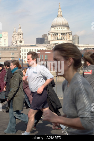 Jogger und Fußgänger am Südufer mit St. Pauls Kathedrale im Hintergrund. London, England Stockfoto