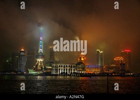 Die Pudong Bezirk von Shanghai aus über den Fluss Huang in der Nacht im wirbelnden Nebel gesehen. Stockfoto