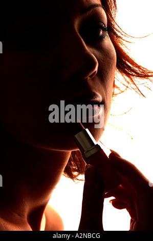 Junge Frau Auftragen von Lippenstift auf den Lippen Stockfoto