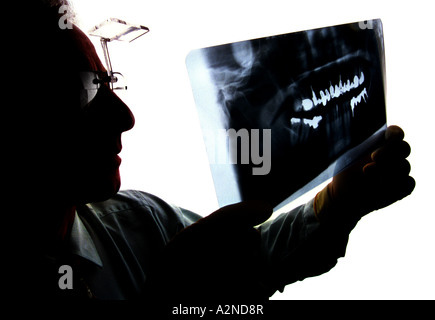 Eine Silhouette eines Zahnarztes untersucht Zahnröntgen. Bild von Jim Holden. Stockfoto