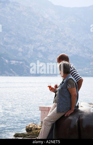 Ein paar mit Weingläsern, die warten auf eines Tisch vom Lago di Garda im Dorf von Malcesine, Italien Stockfoto