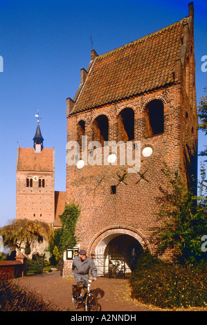 Mann Radfahren vor Kirche St. Johannes Church, Bad Zwischenahn, Ammerland, Niedersachsen, Deutschland Stockfoto