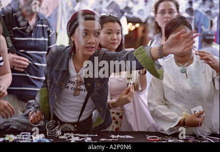 ENGLAND LONDON Young Woman Kundin greift nach einer Kette an einem Stall in der Petticoat Lane Markt Stockfoto