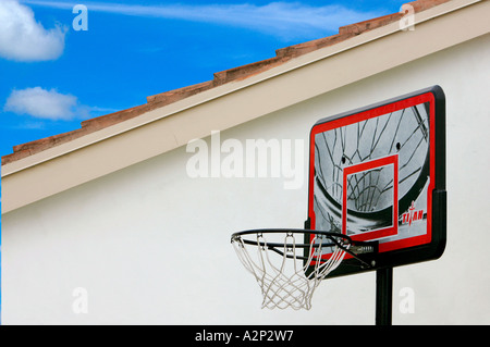 net Basketballkorb vor Haus spielen Abstellgleis zurück Stopp Rücklaufsperre leichte Wolken Abwesenheit Stille Fenster Blau Himmel ruhig Friedenstag Stockfoto