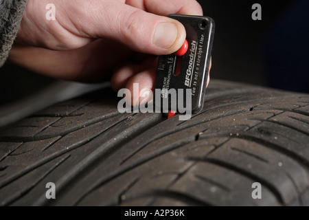 Kontrolle der Reifen-Lauffläche mit einem Messwerkzeug Stockfoto