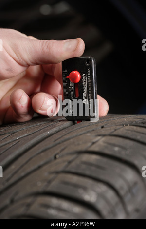 Kontrolle der Reifen-Lauffläche mit einem Messwerkzeug Stockfoto