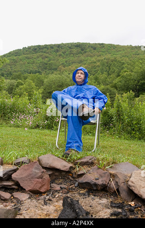 Reifer Mann trägt einen blauen Regenmantel Stockfoto