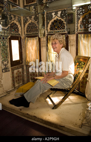 Indien Rajasthan Jodhpur alte Stadt Singhvis Haveli älteren westlichen Frau sitzt in Bed &amp; Breakfast Shisha Zimmer Stockfoto