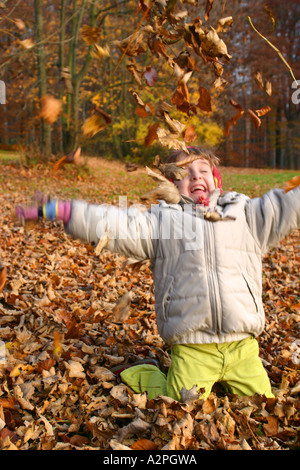 Mädchen spielen im Herbstlaub Stockfoto