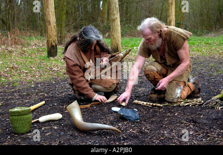 Prähistorischer Mann & Frau Steinzeit Reenactors versuchen, machen Feuer bei The Museum of Welsh Leben St Fagans Cardiff Wales UK Stockfoto