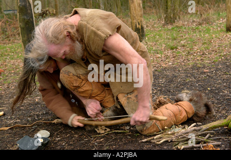 Prähistorischer Mann & Frau Steinzeit Reenactors versuchen, machen Feuer bei The Museum of Welsh Leben St Fagans Cardiff Wales UK Stockfoto