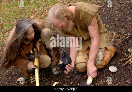 Urmenschen Professional Steinzeit Reenactors knapping Feuerstein bei The Museum of Welsh Leben St Fagans Cardiff Wales UK Stockfoto