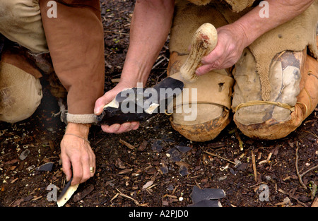 Urmenschen Professional Steinzeit Reenactors knapping Feuerstein bei The Museum of Welsh Leben St Fagans Cardiff Wales UK Stockfoto