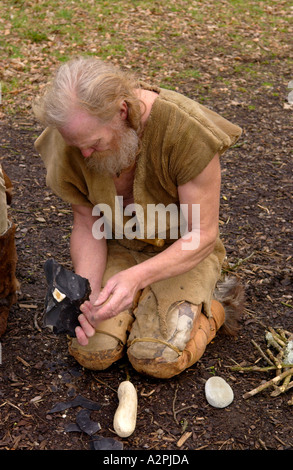 Urmenschen Professional Steinzeit Reenactors knapping Feuerstein bei The Museum of Welsh Leben St Fagans Cardiff Wales UK Stockfoto