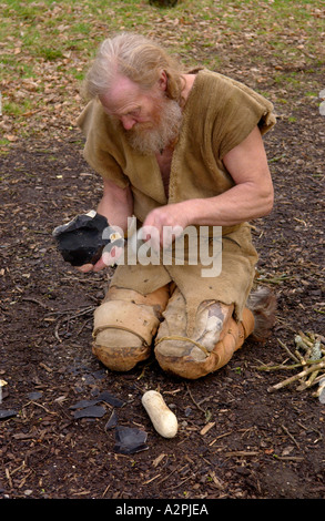 Urmenschen Professional Steinzeit Reenactors knapping Feuerstein bei The Museum of Welsh Leben St Fagans Cardiff Wales UK Stockfoto