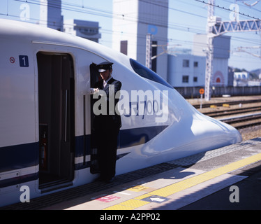 Shinkansen-Hochgeschwindigkeitszug Dirigent blickt seine Uhr Stockfoto