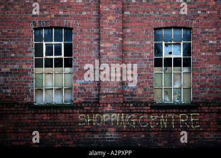 Einem Format Landschaftsbild von einer alten verlassenen Gebäude mit ironischen Graffiti sagen "Einkaufszentrum" unter zertrümmerten Fenstern Stockfoto