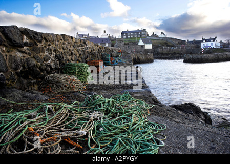 Portsoy alten Hafen an der Küste Banffshire, North East Scotland mit Fischernetzen und ots im Vordergrund. Stockfoto