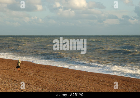 einsame Gestalt zu Fuß am Strand von Brighton, Großbritannien Stockfoto