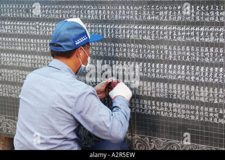 Gravur von Namen auf Marmortafel Mann Stockfoto
