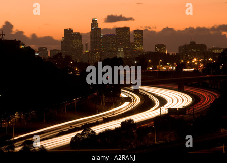 Scheinwerfer und Rückleuchten auf den San Bernardino Freeway Autobahn 10 Sonnenuntergang über LA Skyline Schlieren Stockfoto