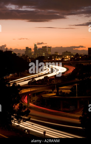 Scheinwerfer und Rückleuchten auf den San Bernardino Freeway Autobahn 10 Sonnenuntergang über LA Skyline Schlieren Stockfoto