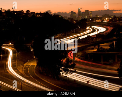 Scheinwerfer und Rückleuchten auf den San Bernardino Freeway Autobahn 10 Sonnenuntergang über LA Skyline Schlieren Stockfoto