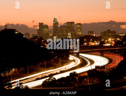 Scheinwerfer und Rückleuchten auf den San Bernardino Freeway Autobahn 10 Sonnenuntergang über LA Skyline Schlieren Stockfoto