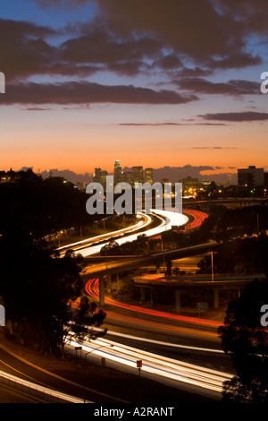 Scheinwerfer und Rückleuchten auf den San Bernardino Freeway Autobahn 10 Sonnenuntergang über LA Skyline Schlieren Stockfoto