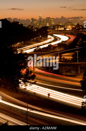 Scheinwerfer und Rückleuchten auf den San Bernardino Freeway Autobahn 10 Sonnenuntergang über LA Skyline Schlieren Stockfoto