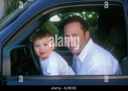 1 Jahr alt gemischt asiatischen kaukasischen junge Stand am Lenkrad mit kaukasischen Papa Stockfoto