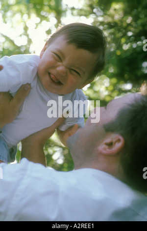 Kaukasische Papa heben gemischt asiatischen kaukasischen einjährigen Sohn Stockfoto