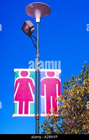 Banner - Grafik männliche und weibliche Figuren auf Banner hängen an einem Lichtmast Stockfoto