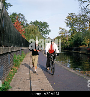 Menschen joggen und Radfahren entlang der Regents Canal im Herbst in London UK KATHY DEWITT Stockfoto