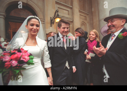 Frisch verheiratete Braut und Bräutigam, die St.-Georgs-Kirche London winkte auf Familie und Freunde zu verlassen Stockfoto