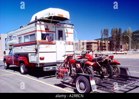 RV Camper Pick-up Ruderboot auf Dach tragen und ziehen Anhänger geladen mit Motocross Dirt Bikes Stockfoto