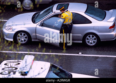 Schreiben ein Ticket für Verletzung Verkehrsstörung auf Autofahrer fahren in einem Auto Polizist Stockfoto