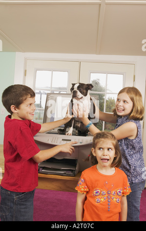 Drei Kinder, einen Hund zu faxen Stockfoto