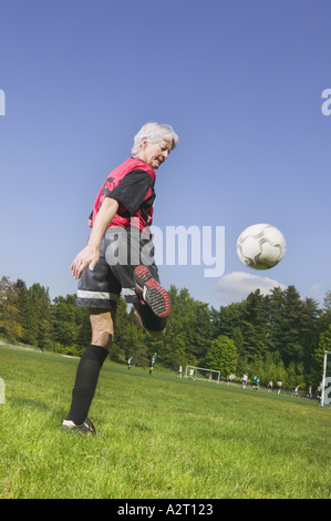 Eine ältere Frau, die Fußball spielen Stockfoto