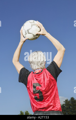 Ein Reife weibliche Fußball-Spieler wirft den Ball in Stockfoto