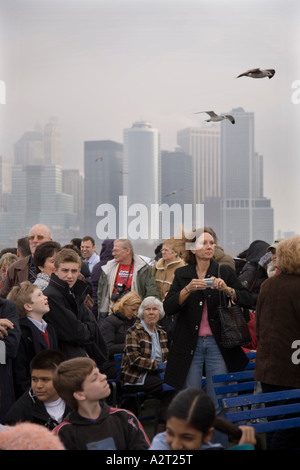 Touristen an Bord die Statue of Liberty Ferry und Ellis Island vom Battery Park von South Ferry Pier New York City Stockfoto