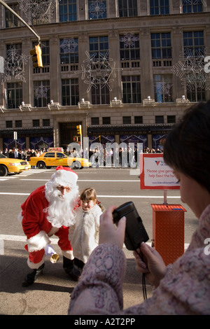 Mädchen trifft Weihnachtsmann in der Nähe von Rockefeller Center und Saks Fifth Avenue New York City USA Stockfoto