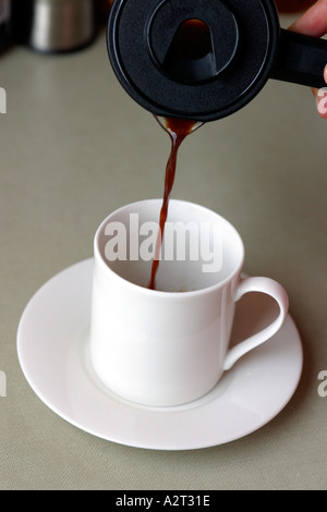 Man gießt Kaffee in Tasse Stockfoto