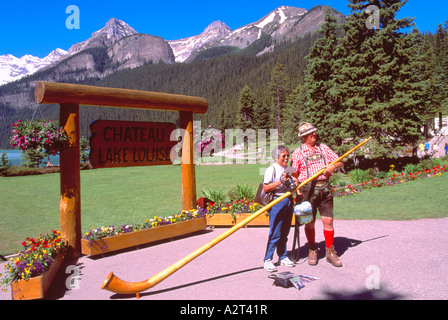 Ein Alphorn Spieler posiert mit Tourist am Lake Louise im Banff Nationalpark in den kanadischen Rocky Mountains Alberta Kanada Stockfoto