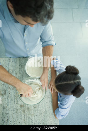 Mädchen beobachten, wie Vater mischt Teig, erhöhte Ansicht Stockfoto